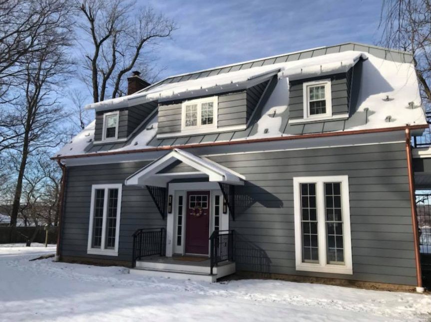 Renovated home in Rhinebeck with gray siding and standing-seam dormer roofs