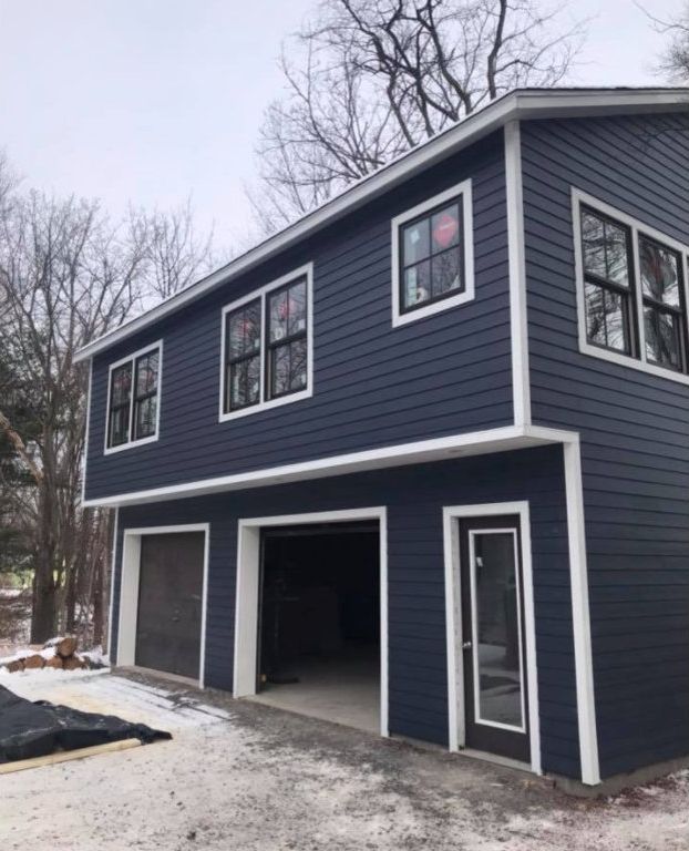 New two-story garage build with navy siding in Hudson